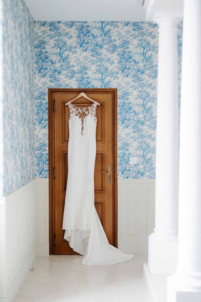 Trieux M.Mann wedding gown hanging by door