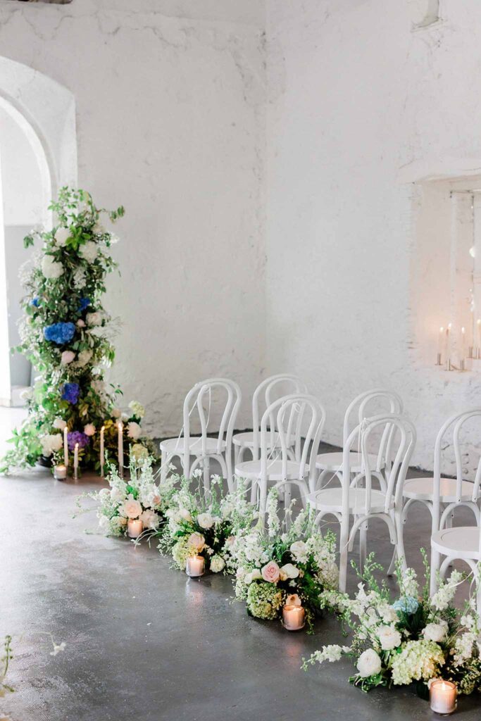 Trieux M.Mann white room ceremony area blue accents flowers