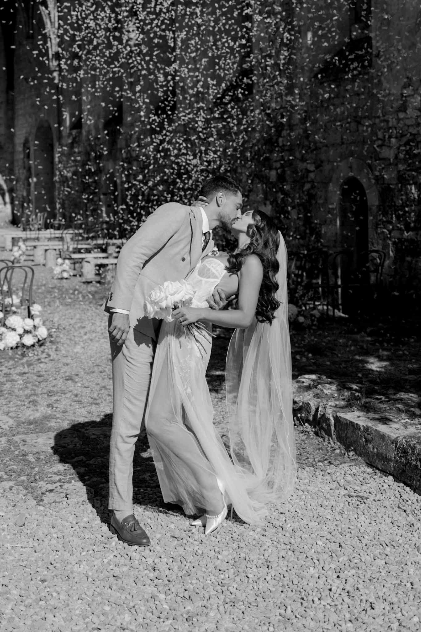 Abbaye Noce Machine bride groom dip kiss confetti black white photo