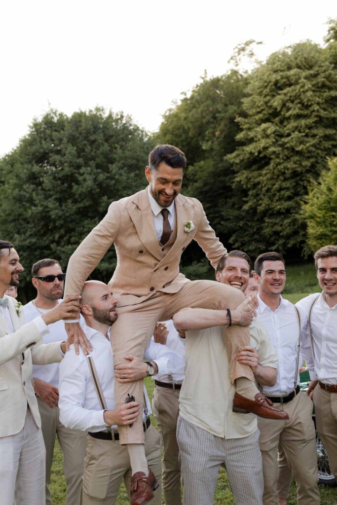 Abbaye Noce Machine groomsmen carrying groom on their shoulder