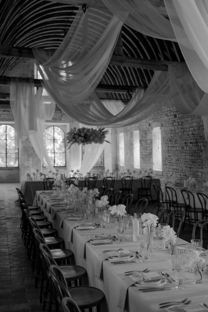 Abbaye Noce Machine long reception table inside ruined old structure black white photo