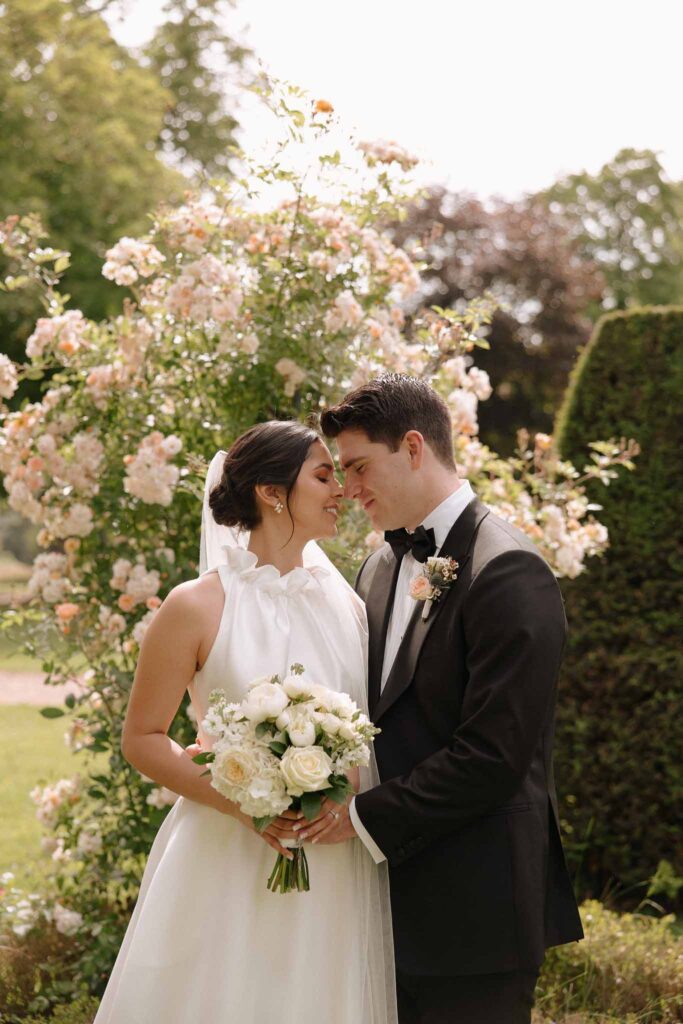 Boutonvillier F.Mary bride groom almost kissing holding bouquet flower background