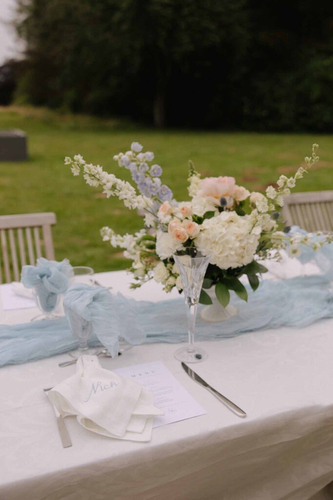 Boutonvillier F.Mary detail shot reception table blue cloth white flowers in vase