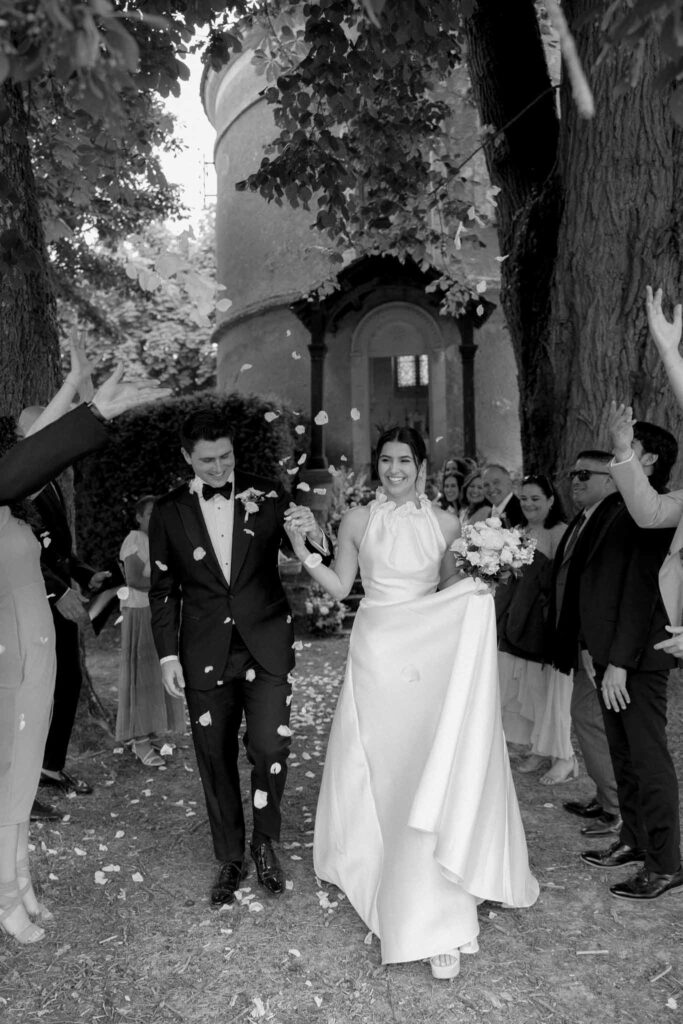 Boutonvillier F.Mary guests toss white petals to couple after ceremony black white photo