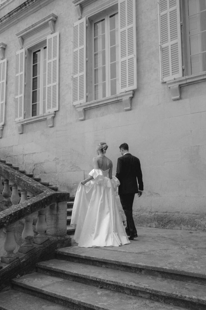 Chateau de Martinay Despinoy Wedding bride groom holding hands walking upstairs outside venue black white photo