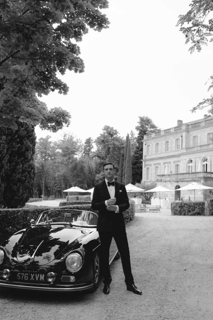 Chateau de Martinay Despinoy Wedding groom standing by vintage car black white photo