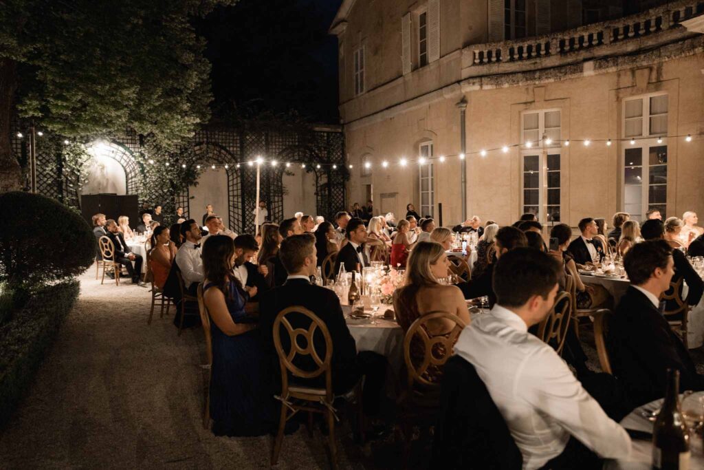 Chateau de Martinay Despinoy Wedding guests seated reception string lights outside