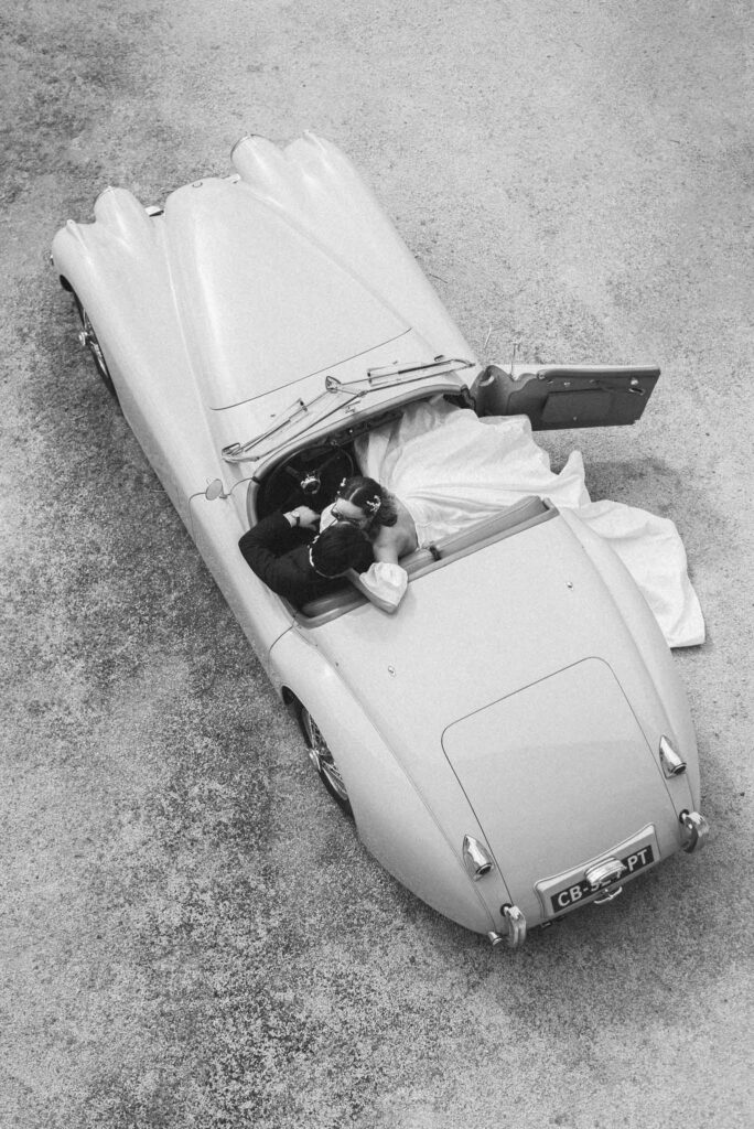 L Amour Fou 3 Maude C Photographe bride groom kissing inside vintage car top shot