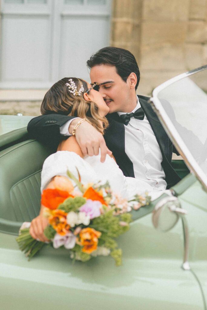 L Amour Fou 3 Maude C Photographe bride groom kissing sitting vintage car