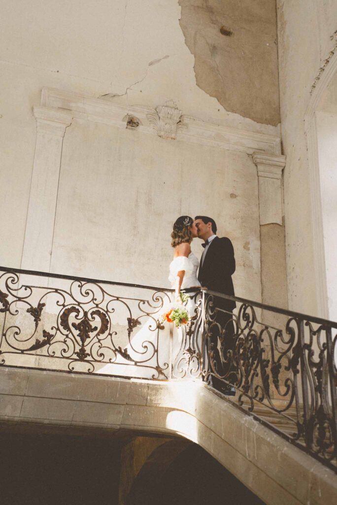 L Amour Fou 3 Maude C Photographe bride groom kissing upstairs vintage old building