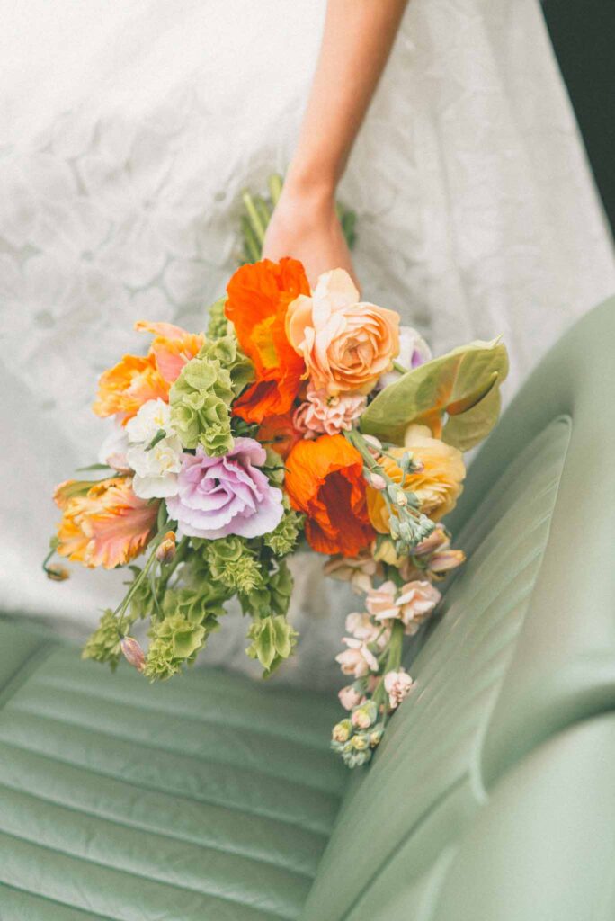 L Amour Fou 3 Maude C Photographe detail shot bride holding colorful bouquet