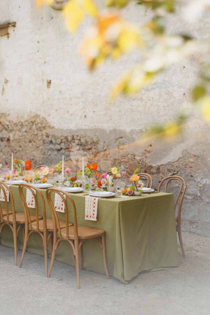 L Amour Fou 3 Maude C Photographe long table wood chairs colorful flower decor reception close up