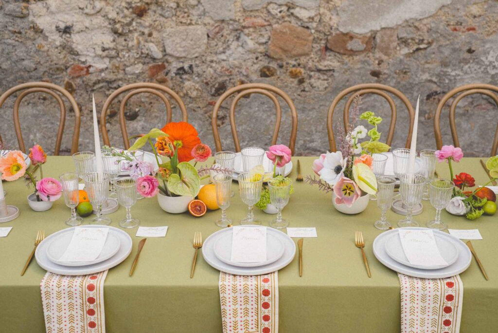 L Amour Fou 3 Maude C Photographe wood chairs colorful flower wine glasses reception table wide shot