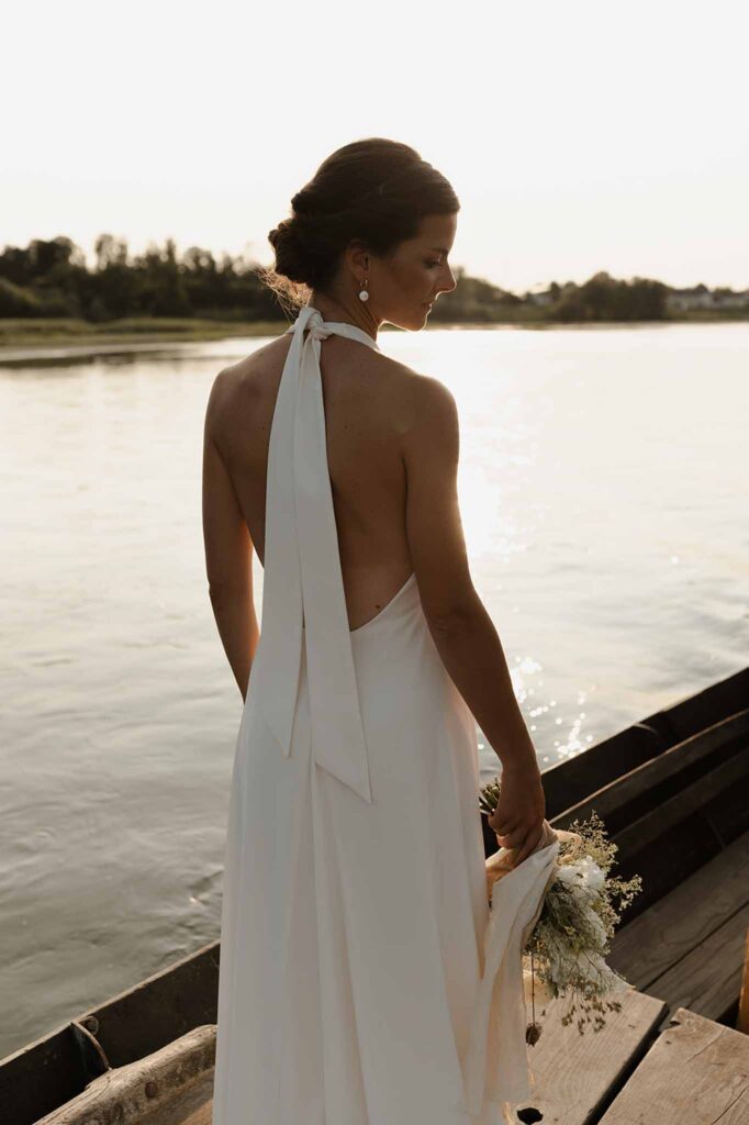 Loire Valley Il Keys bride backshot backless halter dress holding bouquet river sunset