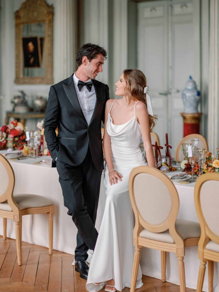 Marcellus Q.H.Quinze bride groom looking each other standing beside reception table