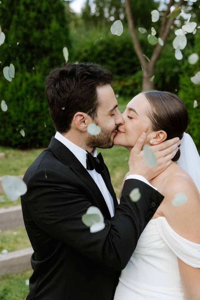 Mariage dime de giverny bride groom holding face kissing white petals toss