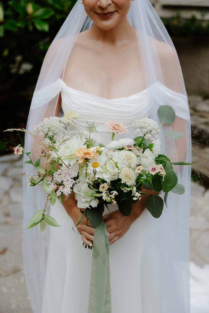 dime de giverny bride holding wild white blush bouquet