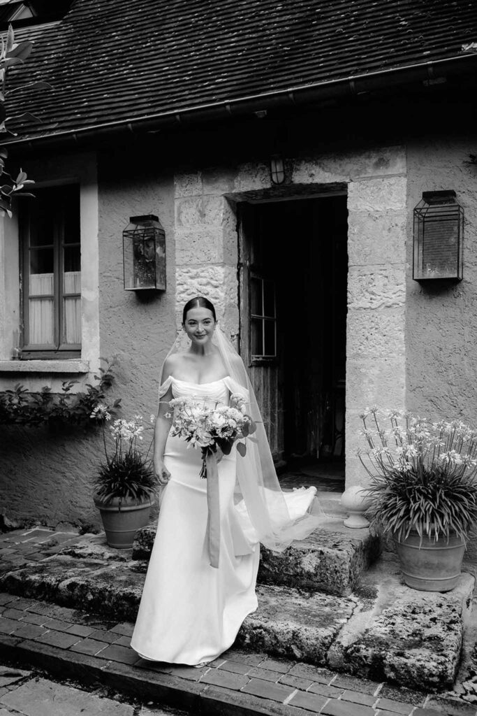 bride walking out house black white photo