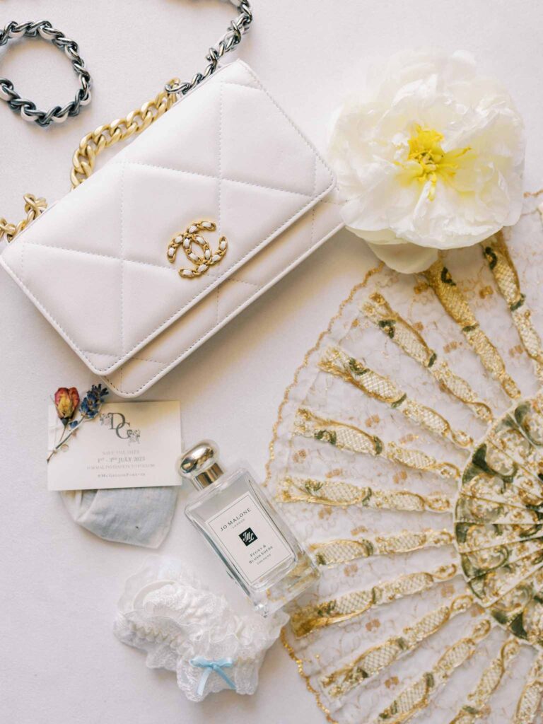 g.dominic m.marechal accessories white bag perfumes fan flatlay shot