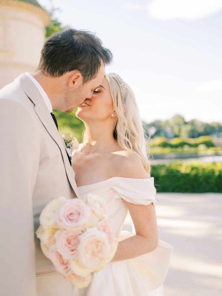 g.dominic m.marechal bride groom kissing bride holding bouquet