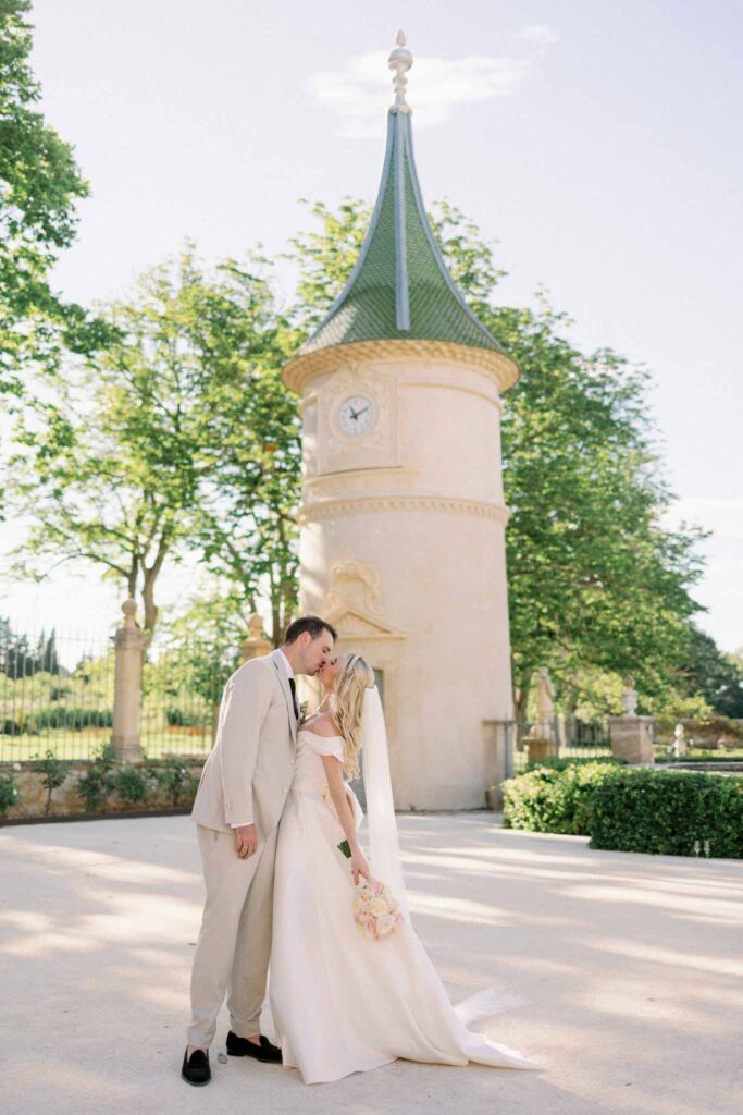 g.dominic m.marechal bride groom kissing castle background