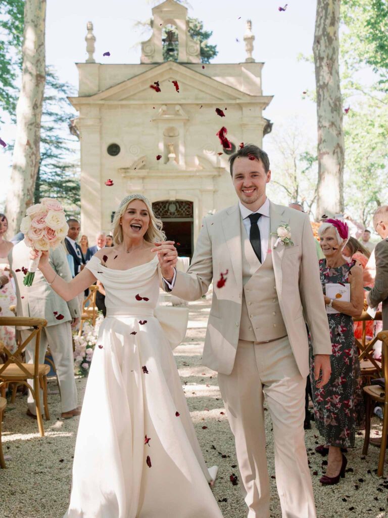 g.dominic m.marechal bride groom walking out ceremony red petals toss