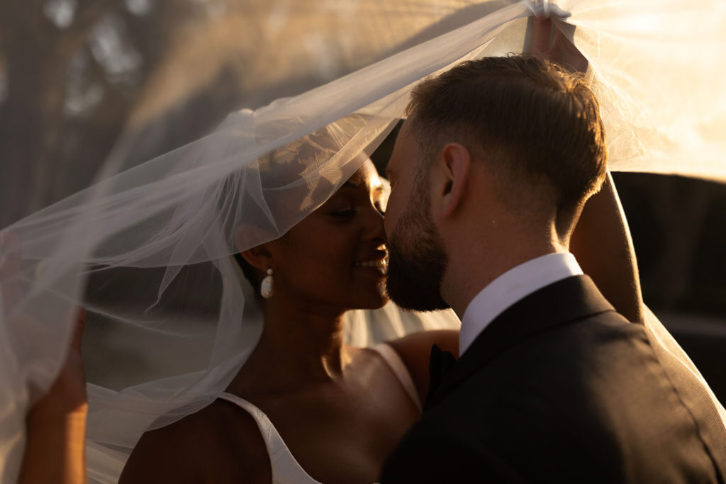 Bastide du Roy J.Jellet bride groom kissing inside veil sunset close up