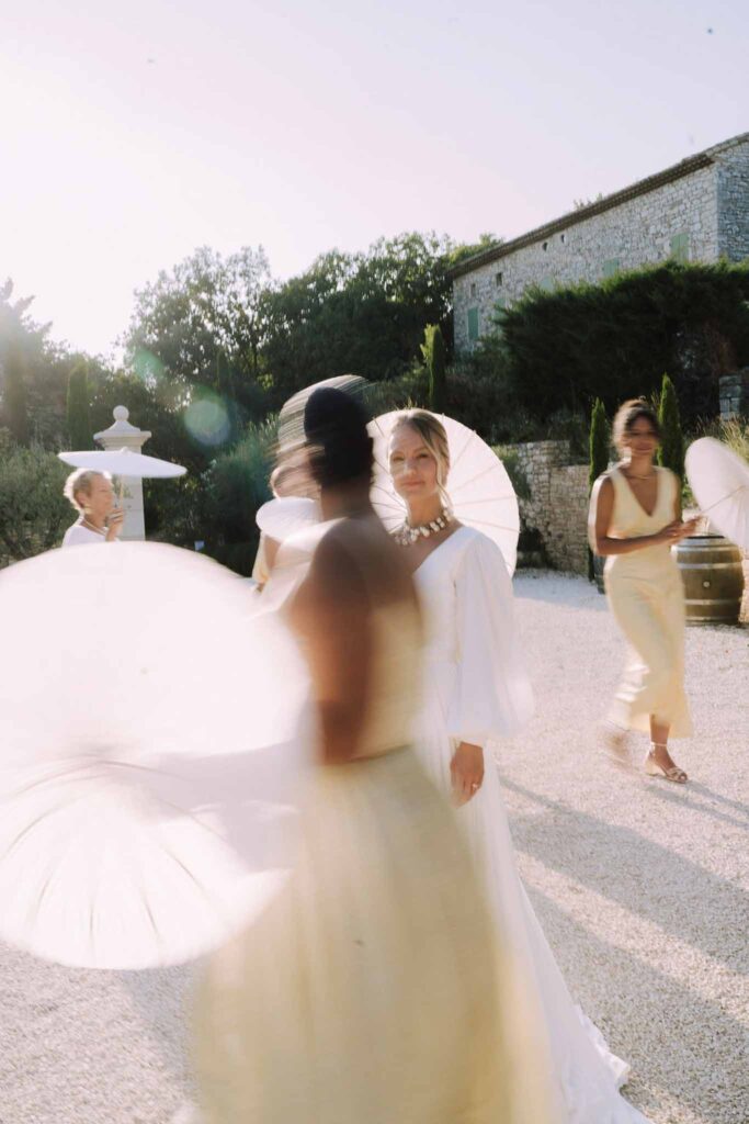 Clos d Hullias Ozaria bride bridesmaids walking circle the bride holding umbrella blur