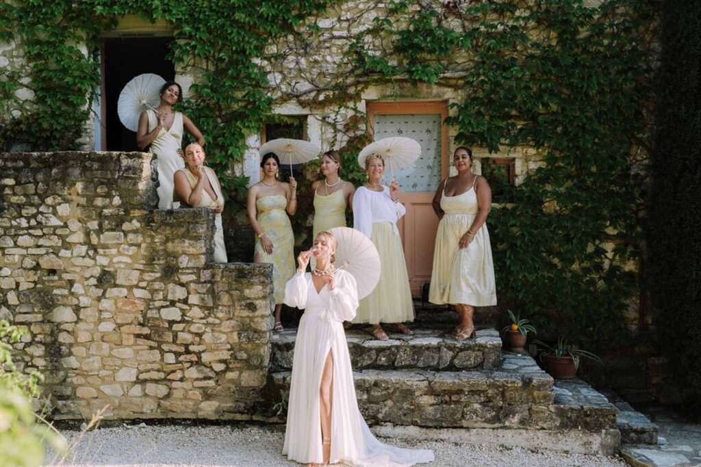 Clos d Hullias Ozaria bride drinking wine bridesmaids stairs holding white umbrellas