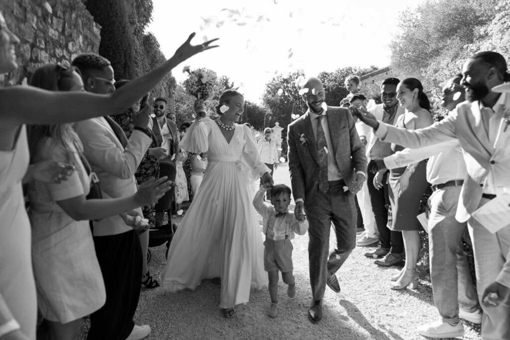 Clos d Hullias Ozaria bride groom child walking flower petals toss guests black white photo