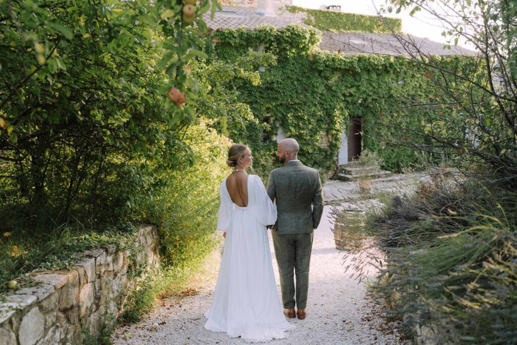 Clos d Hullias Ozaria bride groom looking each other back shot trees wall background