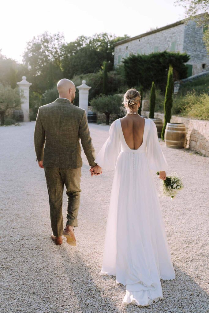 Clos d Hullias Ozaria bride groom walking holding hands sunset backshot