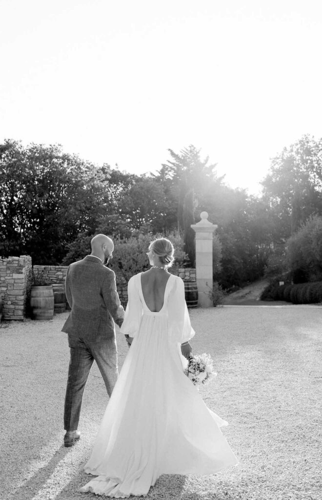 Clos d Hullias Ozaria bride groom walking holding hands sunset backshot black white photo sunset