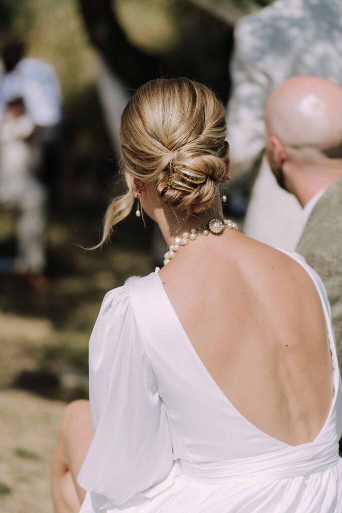 Clos d Hullias Ozaria detail shot bride low back dress low bun hair pearl necklace