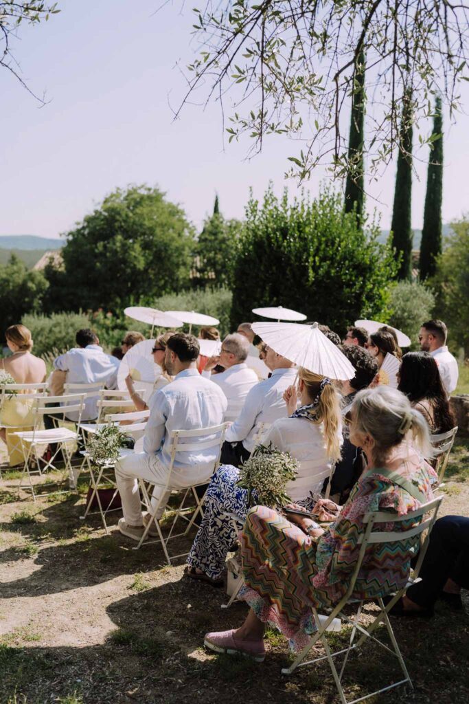 Clos d Hullias Ozaria guests seated white umbrella white chair ceremony proper