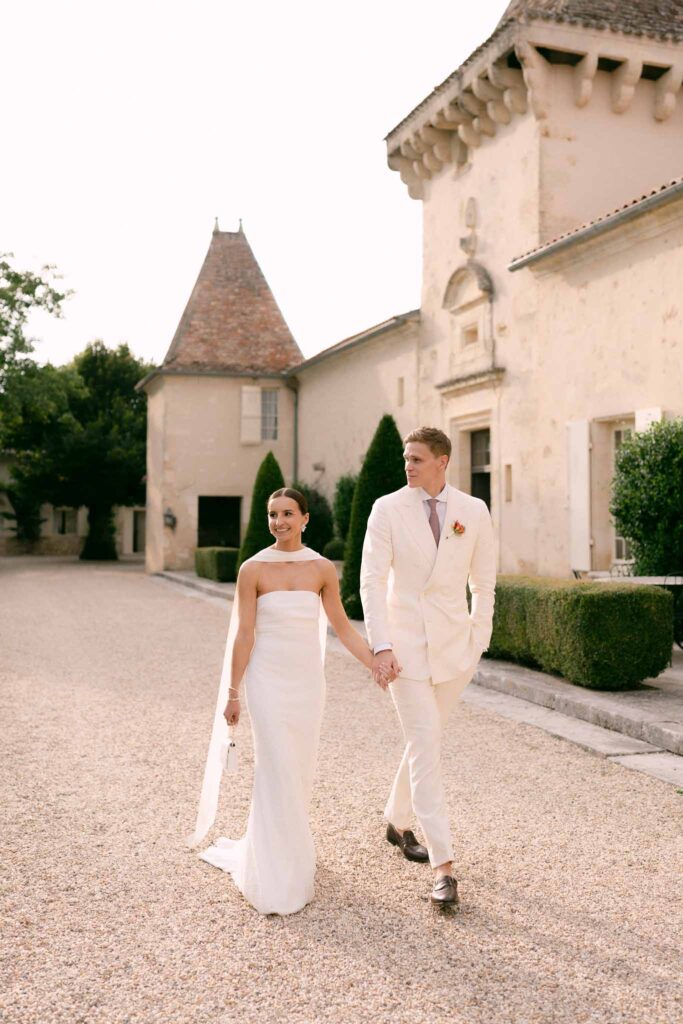 bride and groom wlaking in the front of chateau soulac