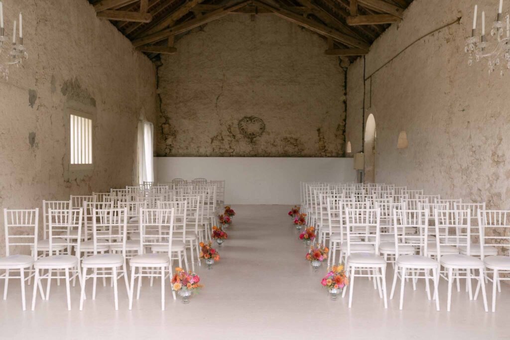 Soulac E.Jane ceremony area white tiffany chairs colorful flowers