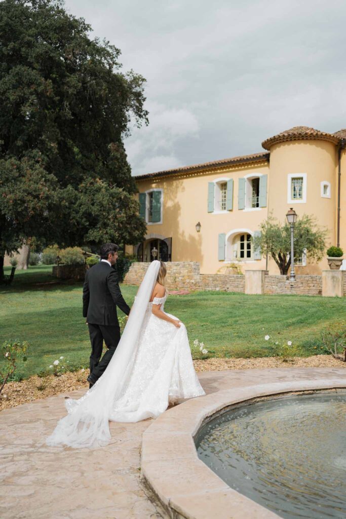 lesCrostes Ingrid bride groom walking fountain long veil back shot