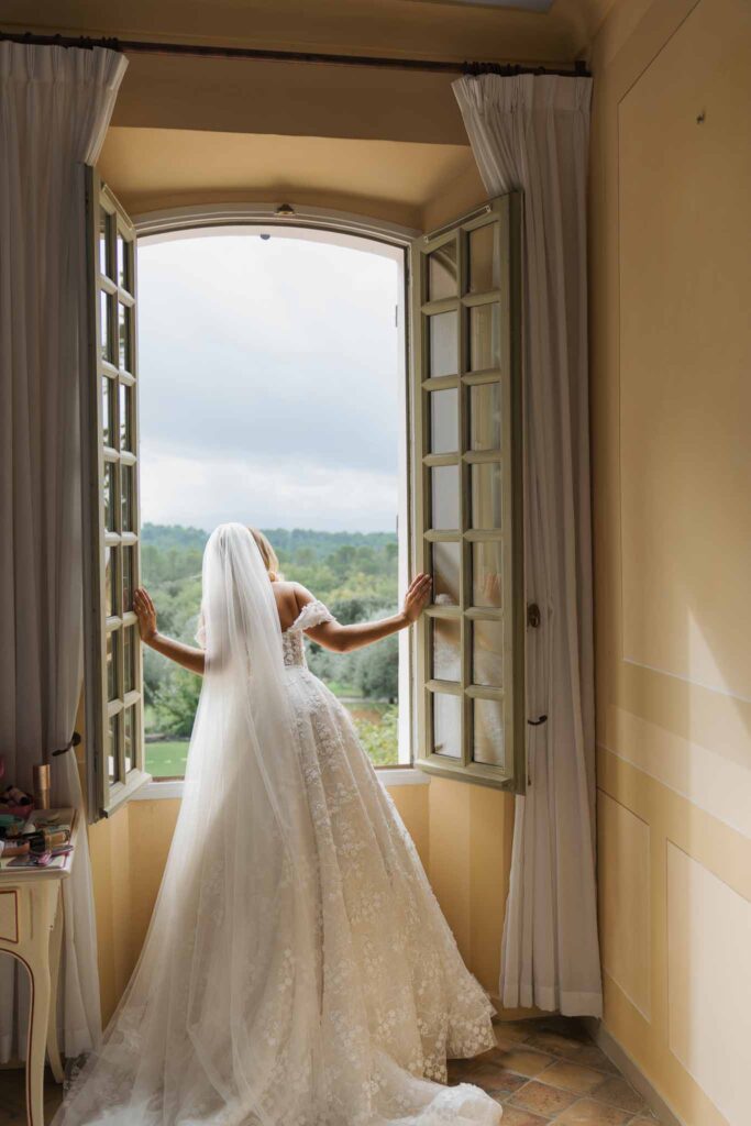 lesCrostes Ingrid bride looking out window long trail veil back shot