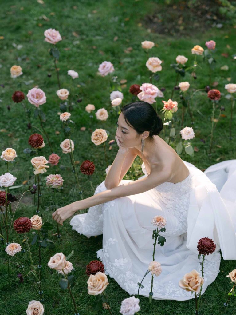 Manoir de Vacheresse Capucine bride sitting grass flowers around garden