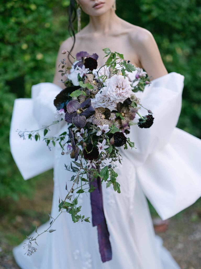 Manoir de Vacheresse Capucine detail shot bride holding dark wild flower bouquet