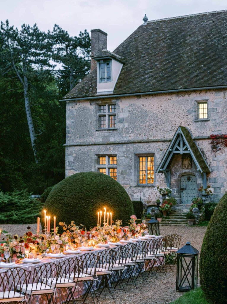 Manoir de Vacheresse wedding editorial reception table metal chairs dark flowers candles lit up old house