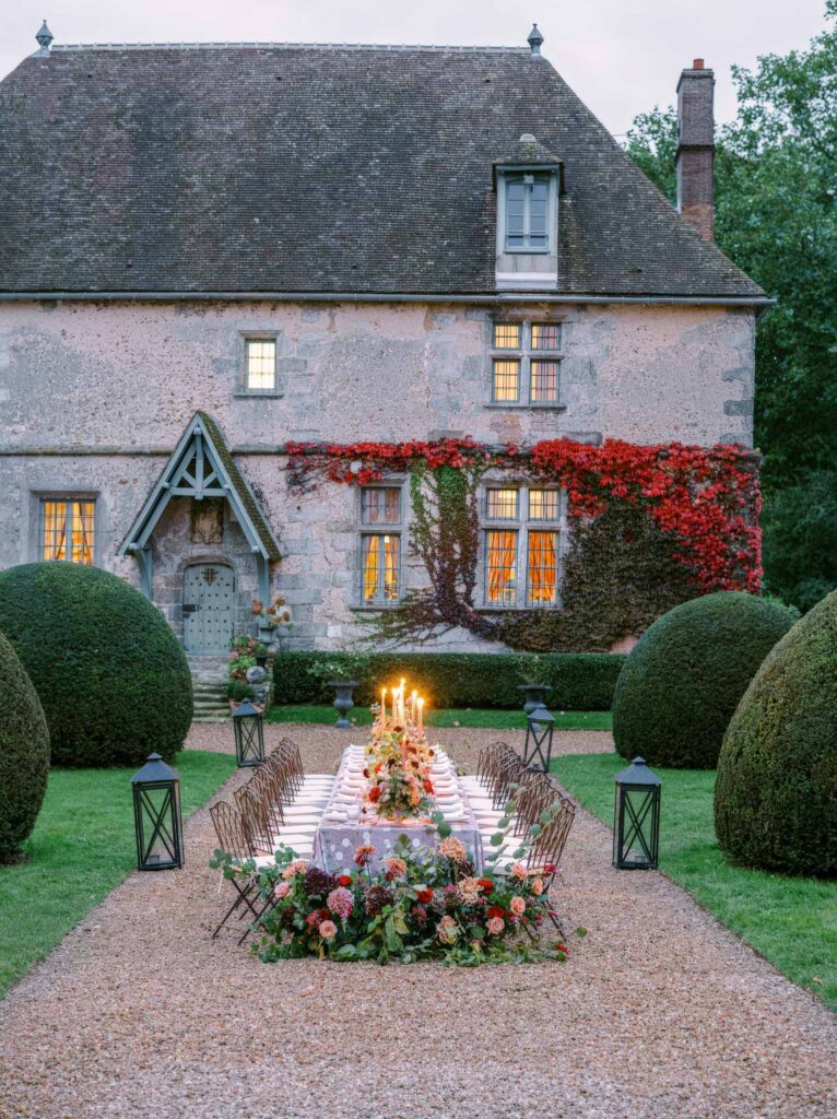 Manoir de Vacheresse Capucine reception table metal chairs dark flowers candles old house background